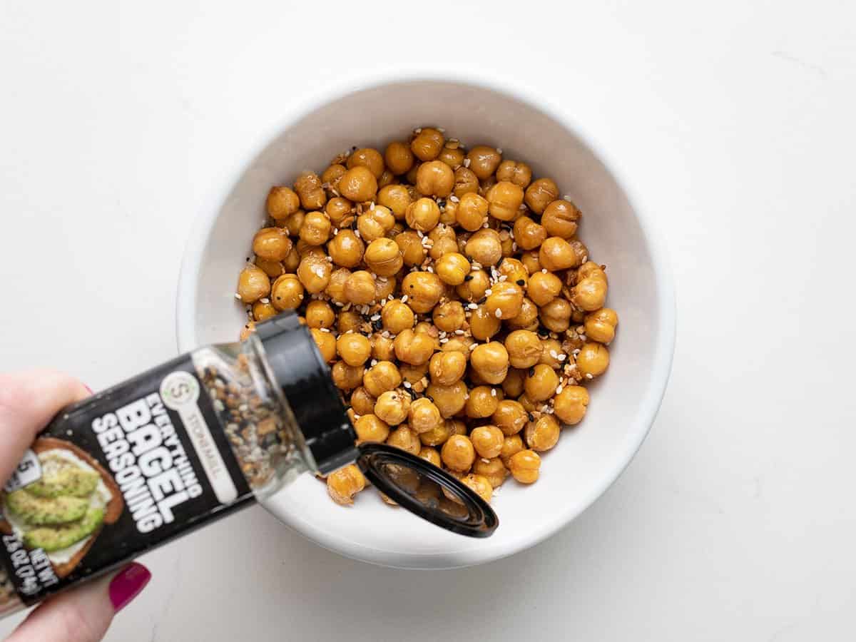 Seasoning being sprinkled over air fried chickpeas.