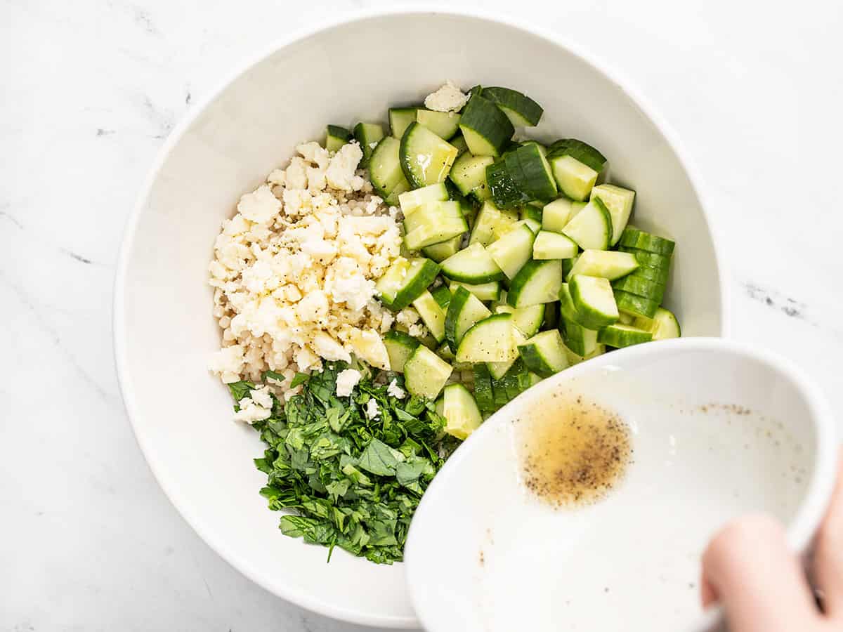 Dressing being poured over the salad.