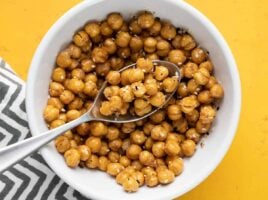 Close up overhead view of a bowl full of air fryer chickpeas with a spoon.