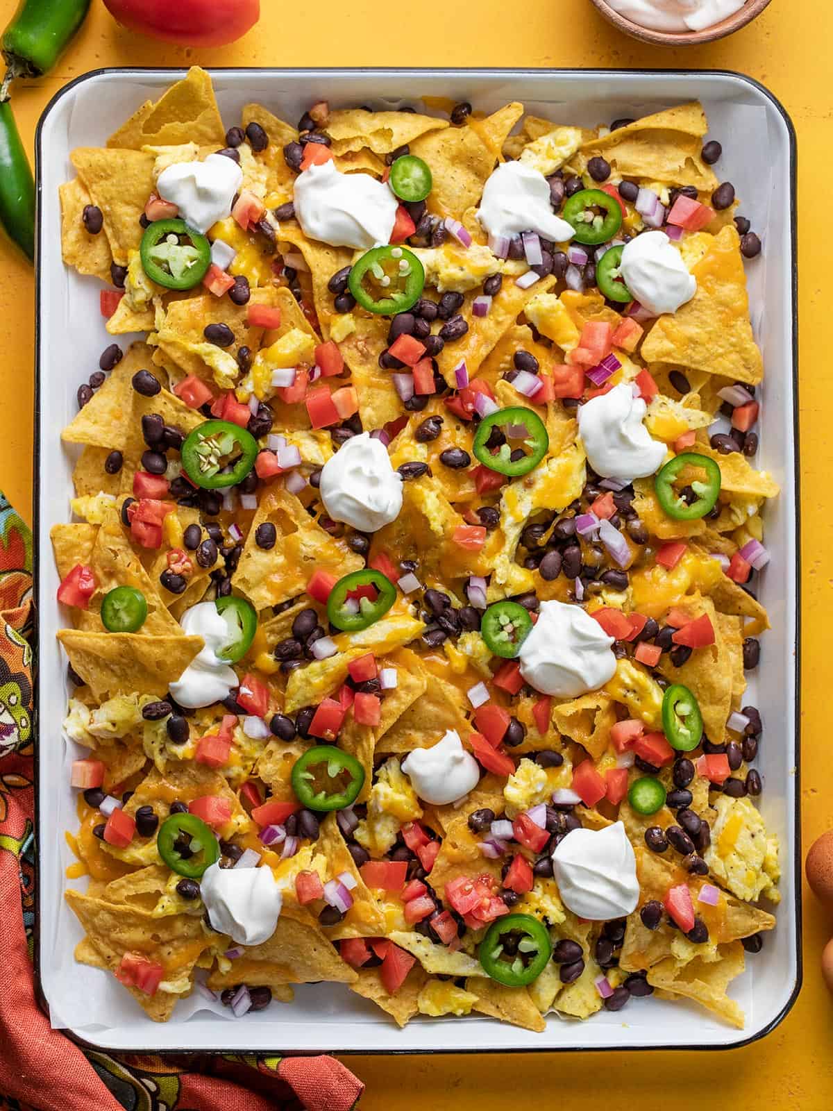Overhead view of a sheet pan full of breakfast nachos.
