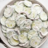 Close up overhead view of a plate full of creamy cucumber salad.
