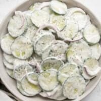 Close up overhead view of a plate full of creamy cucumber salad.