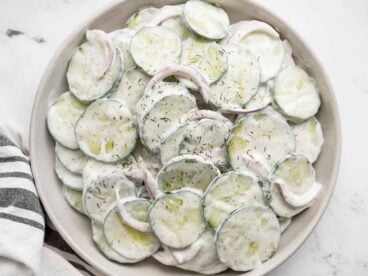 Close up overhead view of a plate full of creamy cucumber salad.