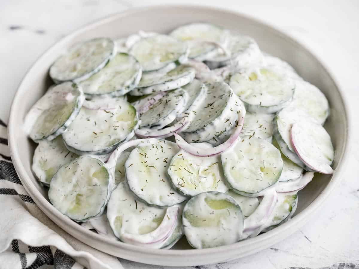 side view of a plate of creamy cucumber salad.