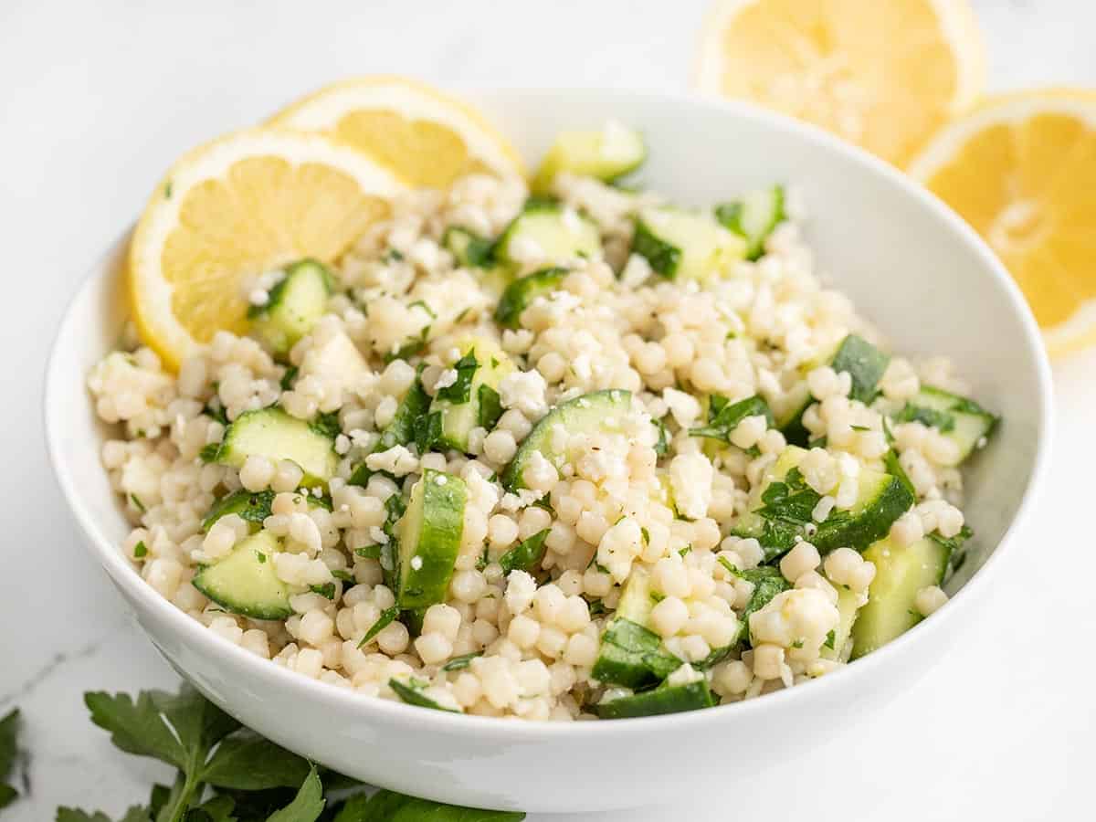 Side view of a bowl of lemony cucumber couscous salad.