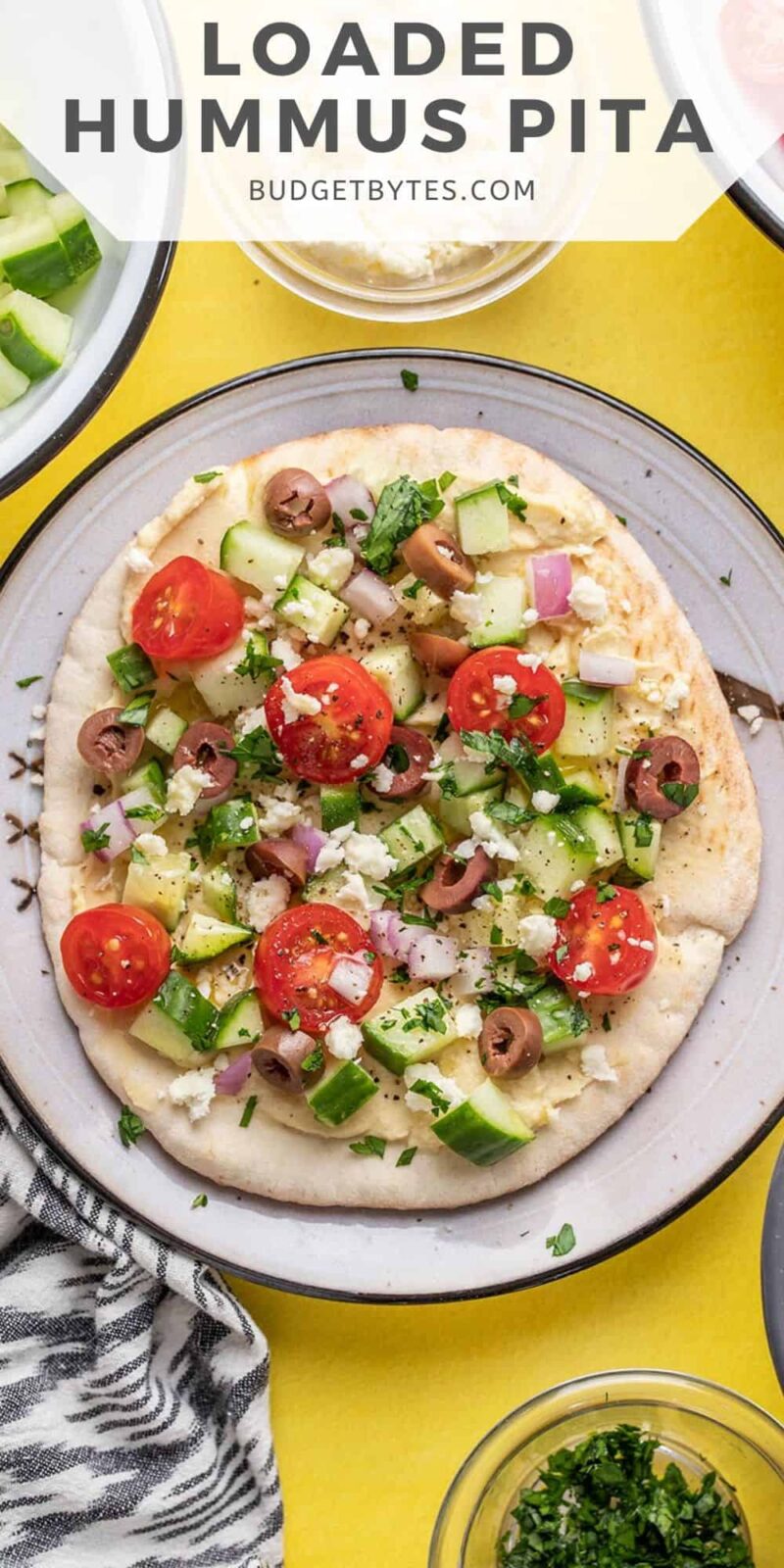 Overhead view of loaded hummus pita on a plate.