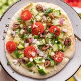 close up view of loaded hummus pita.