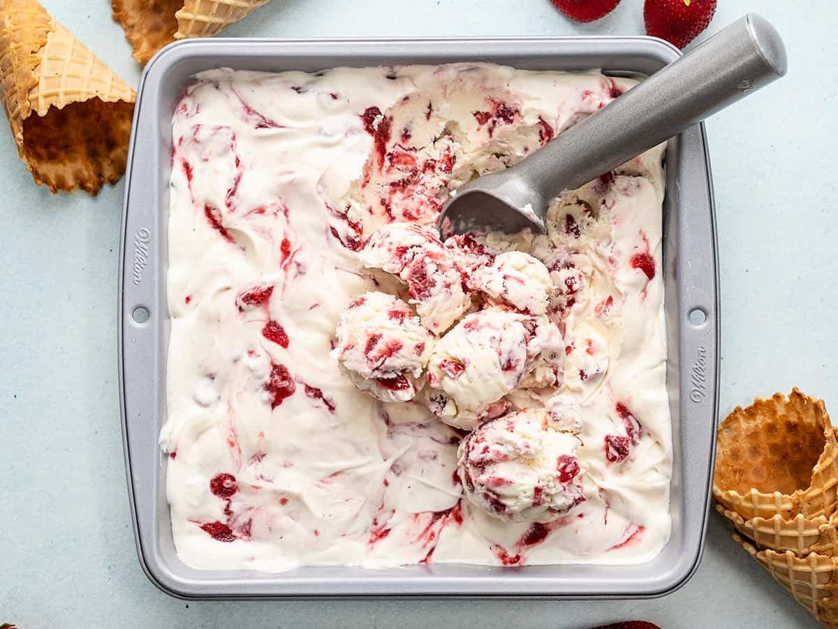 No Churn Strawberry Ice Cream being scooped out of the baking dish.