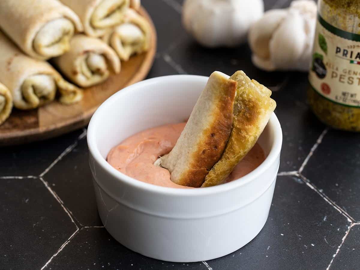 Pesto mozzarella roll up dipped into the bowl of creamy tomato sauce.