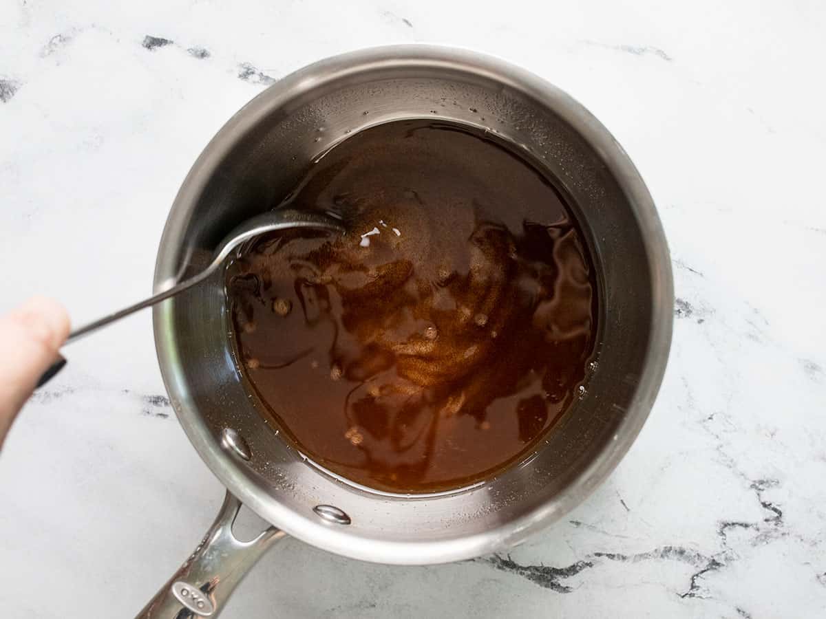 Sugar, oil, and spices in a saucepot.