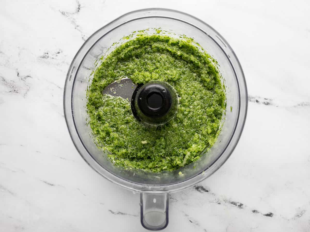 Overhead shot of blended sofrito in the bowl of a food processor.