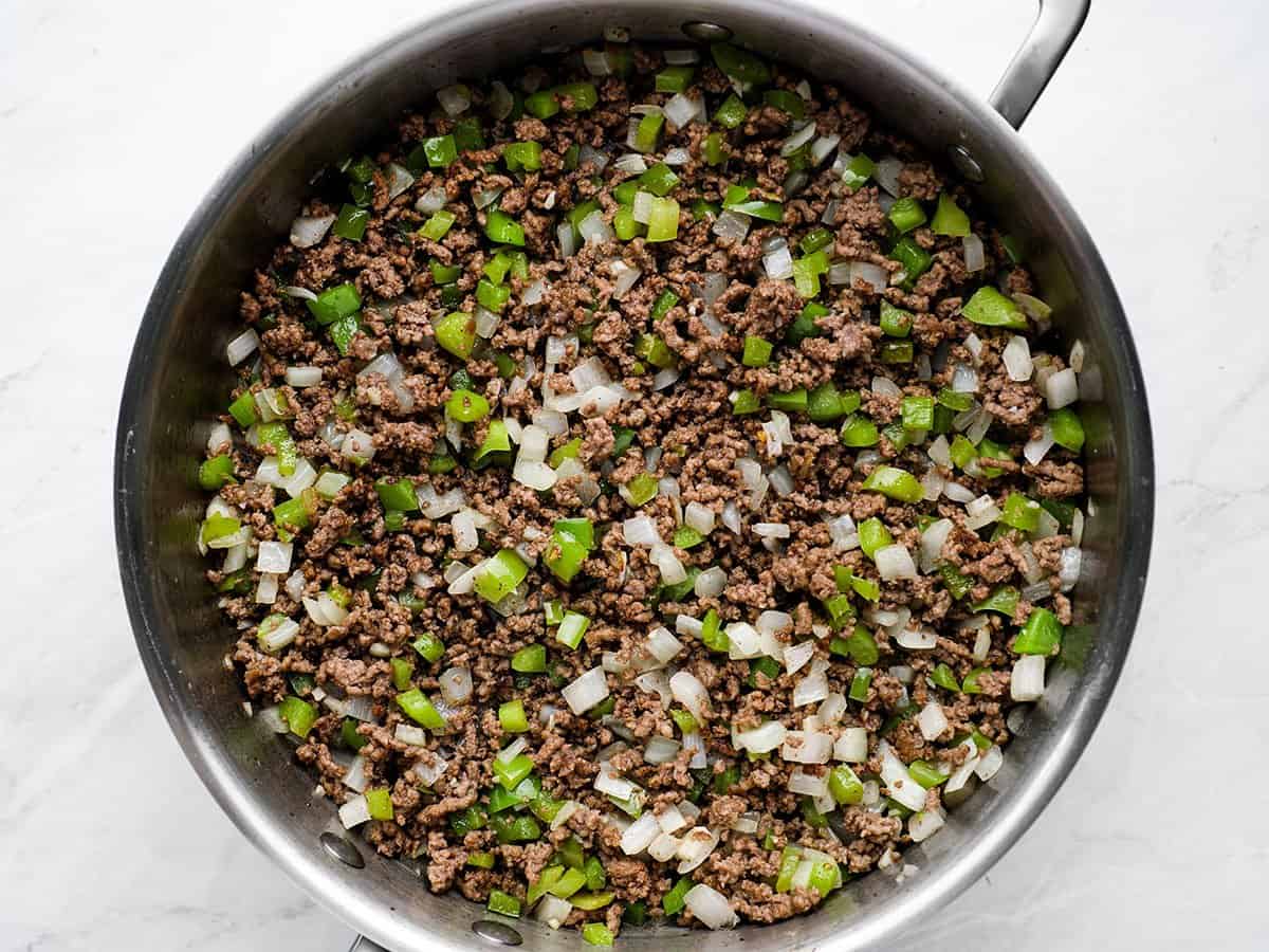 Vegetables added to ground beef in the skillet.