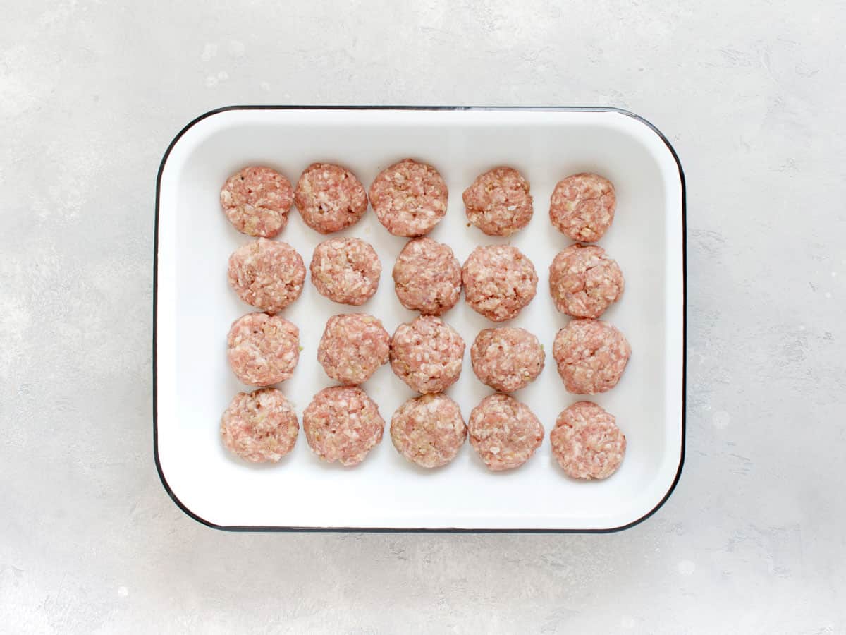 Shaped meatballs in a casserole dish.