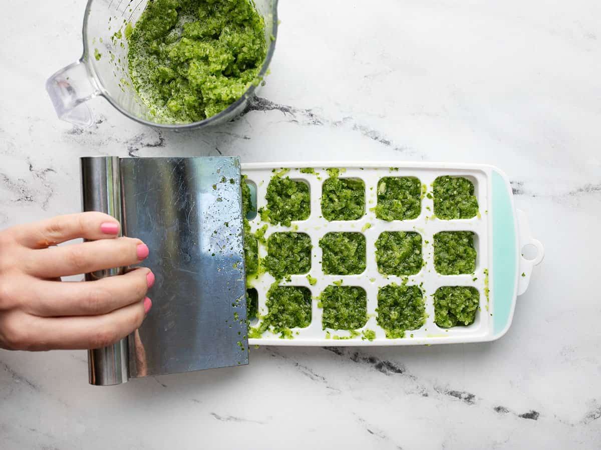 Sofrito being portioned into an ice cube tray.