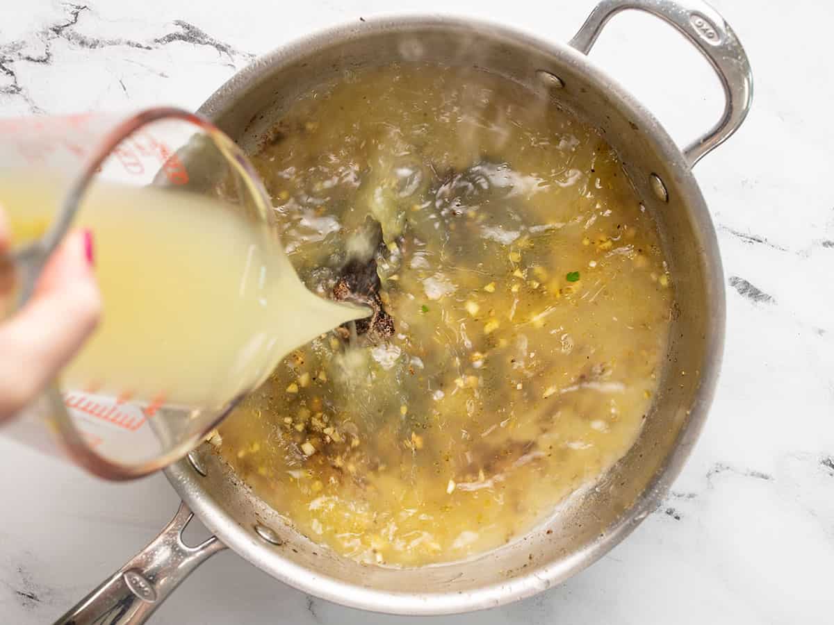 Broth being poured into the skillet.