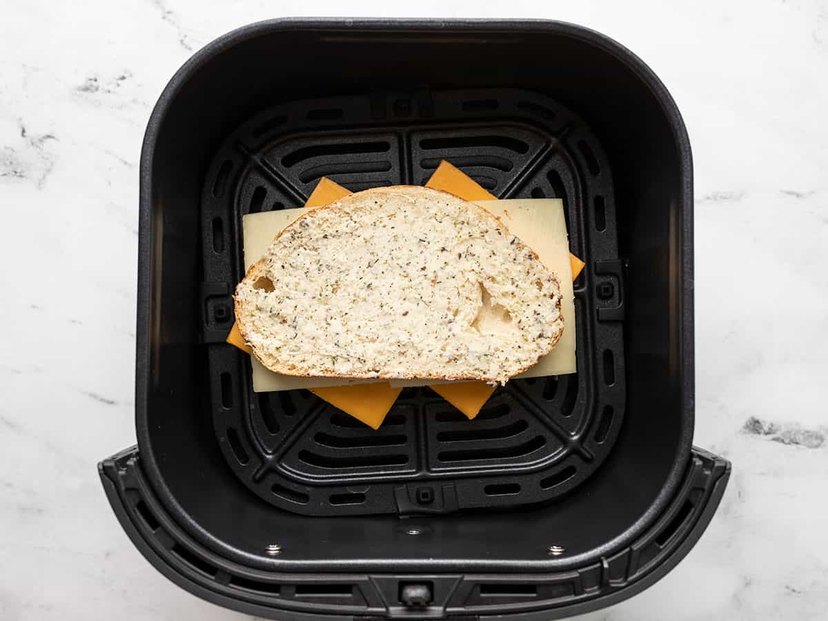 Grilled cheese sandwich in an air fryer basket.
