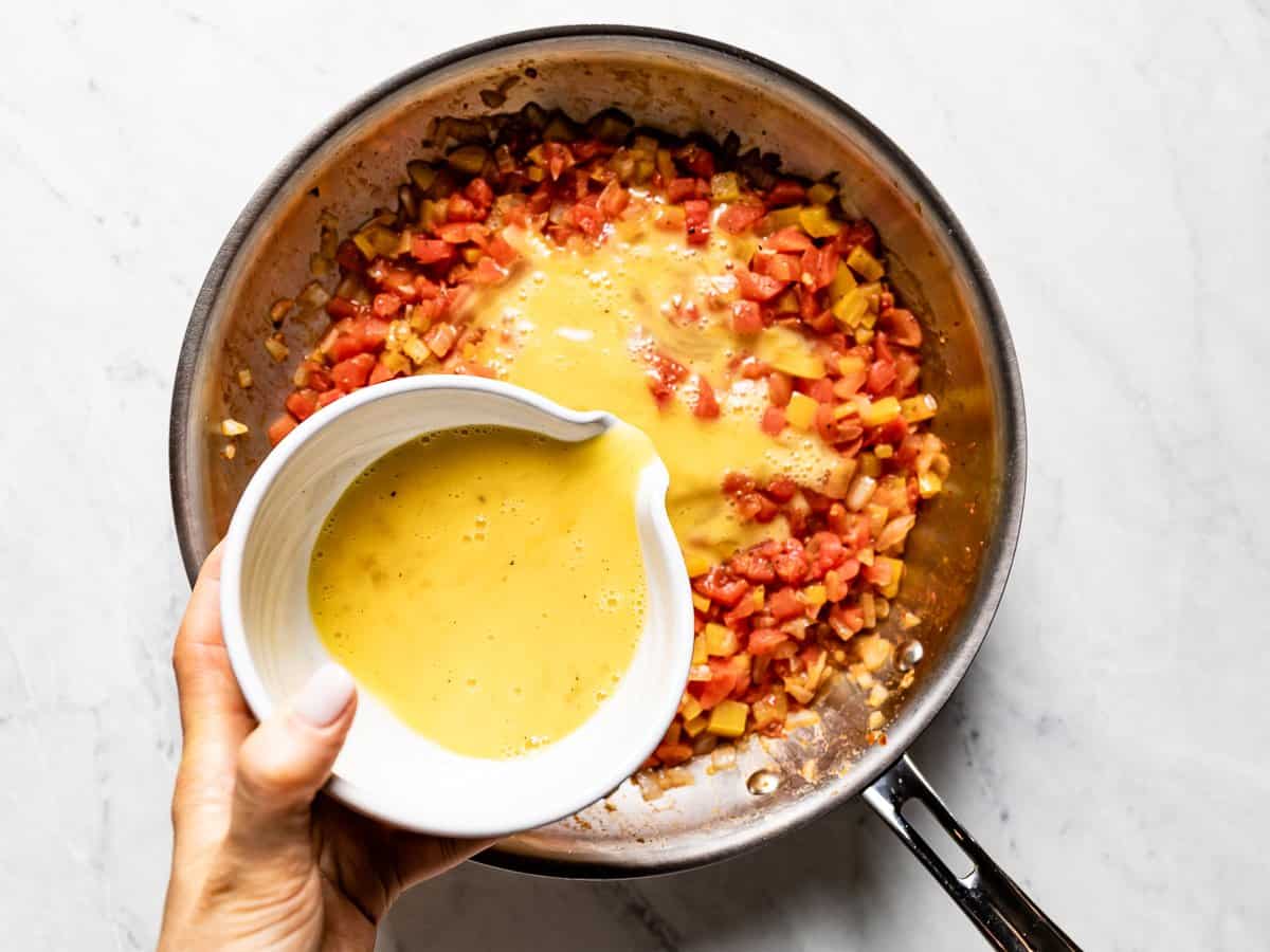 Beated eggs being poured into the skillet.