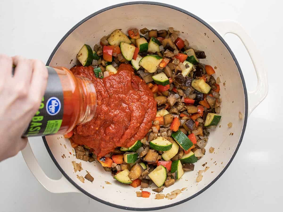 pasta sauce being poured into the pot.