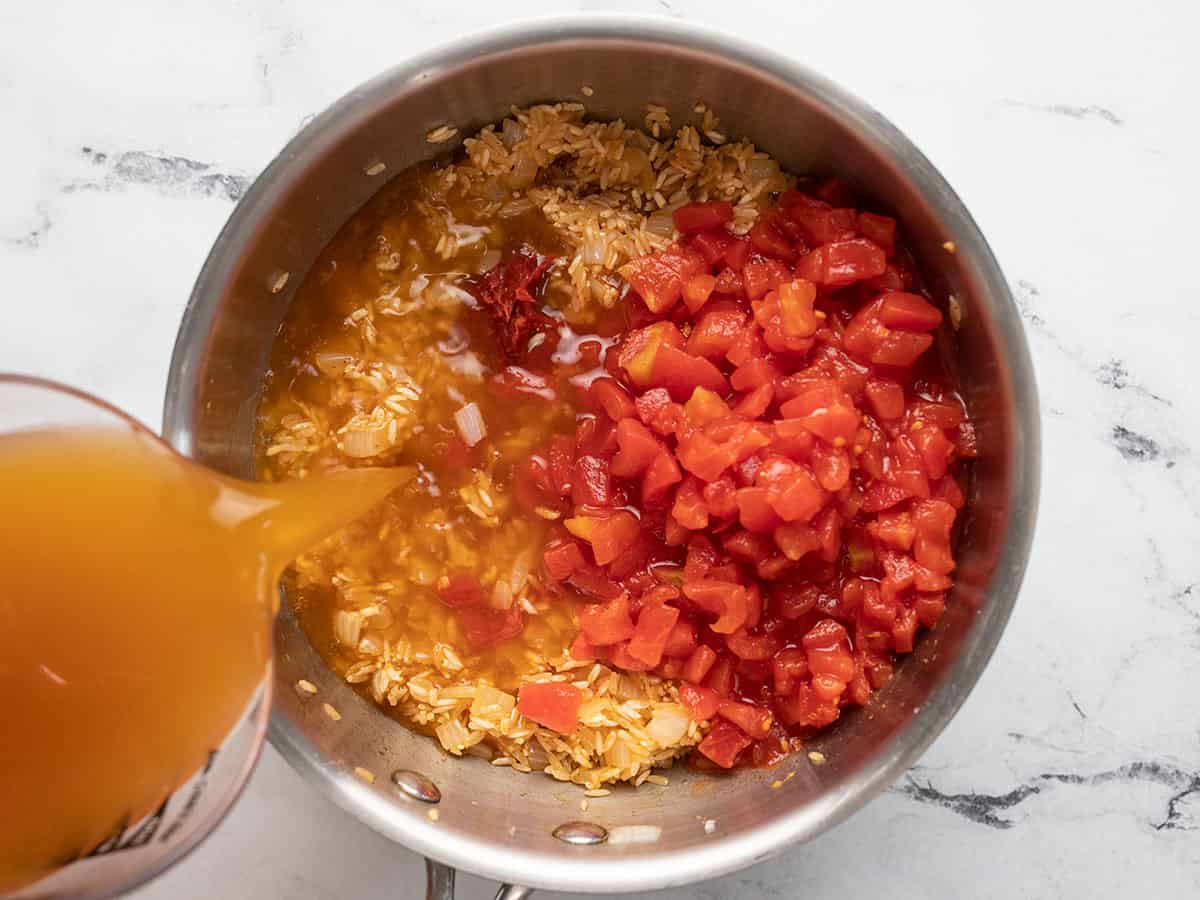 Tomatoes and broth added to the pot.