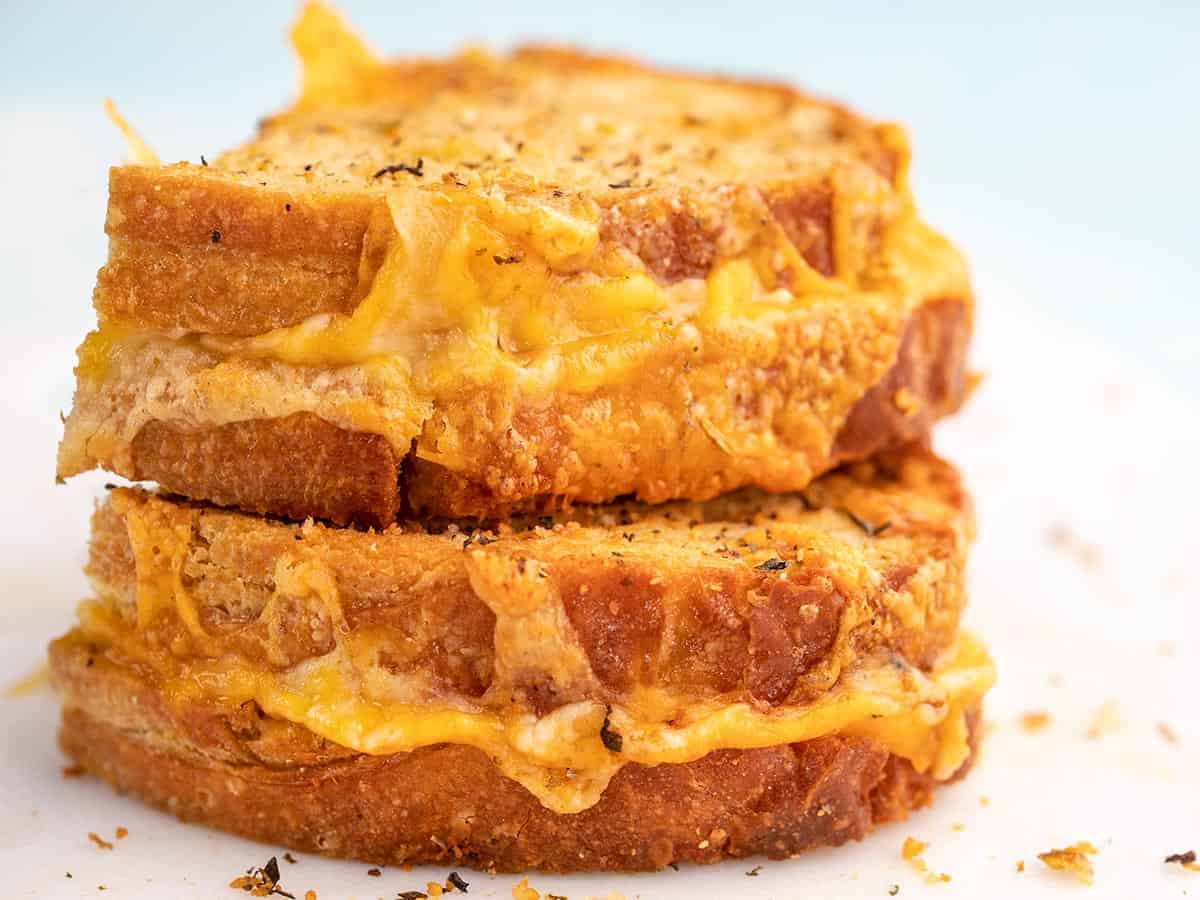 Air Fryer grilled cheese stacked on white plate.