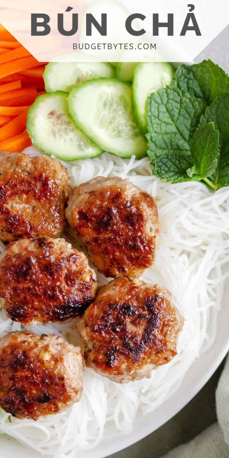 Close up of Bún chả in a bowl with rice noodles and vegetables.