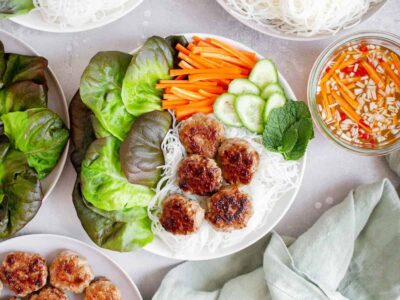Overhead view of Bún chả in a bowl with rice noodles and vegetables.
