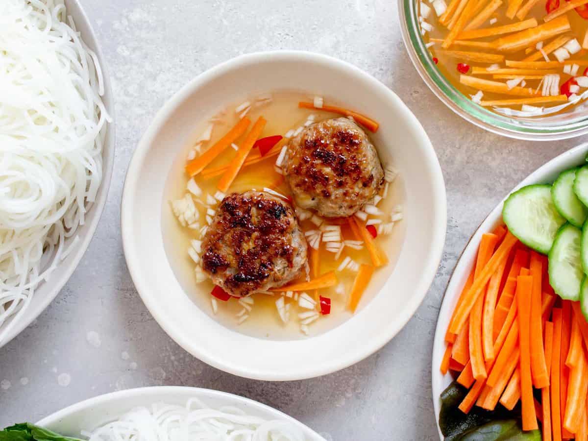 Bún chả in a bowl of dipping sauce.