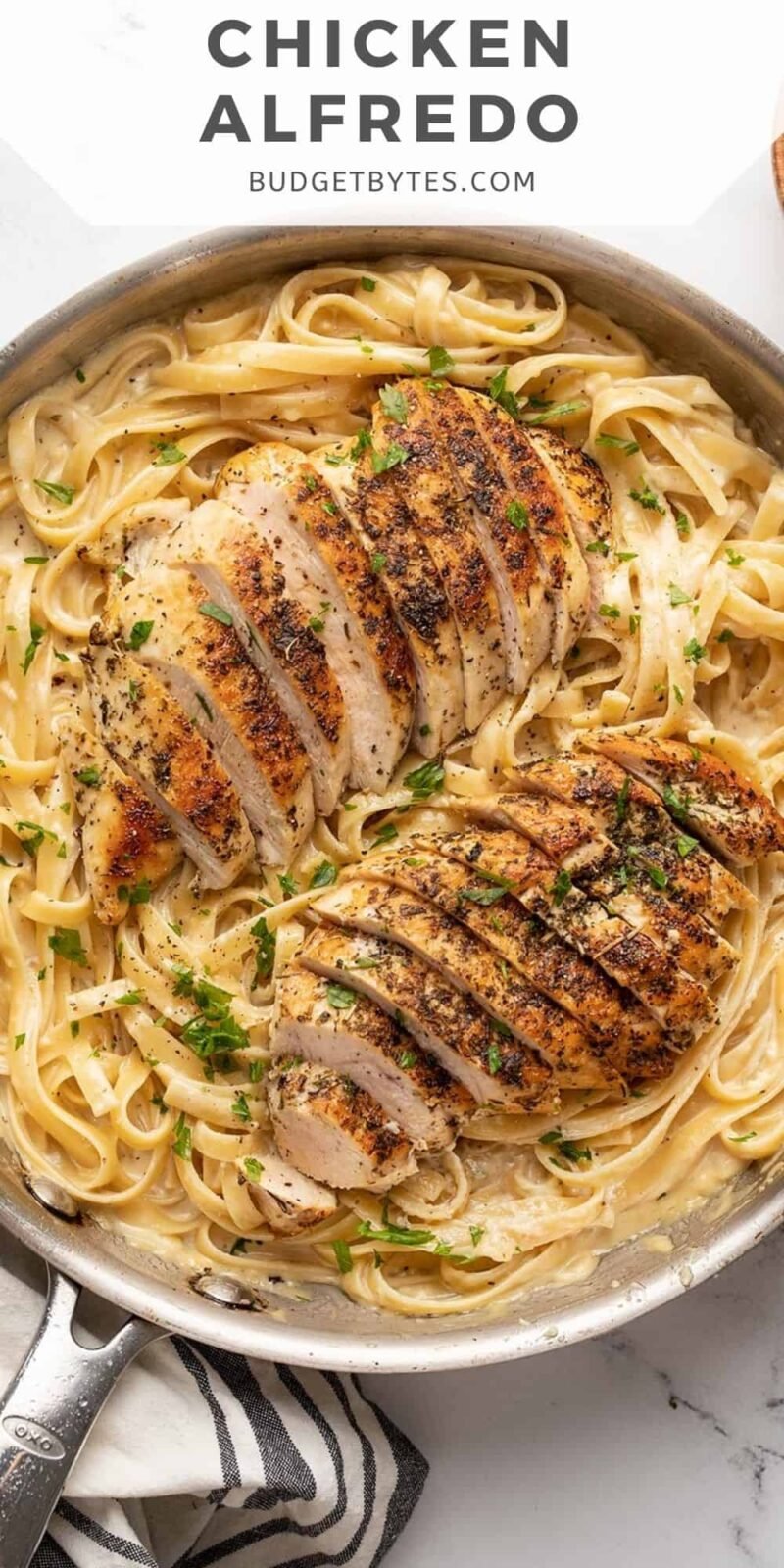 Overhead view of a skillet full of chicken alfredo.