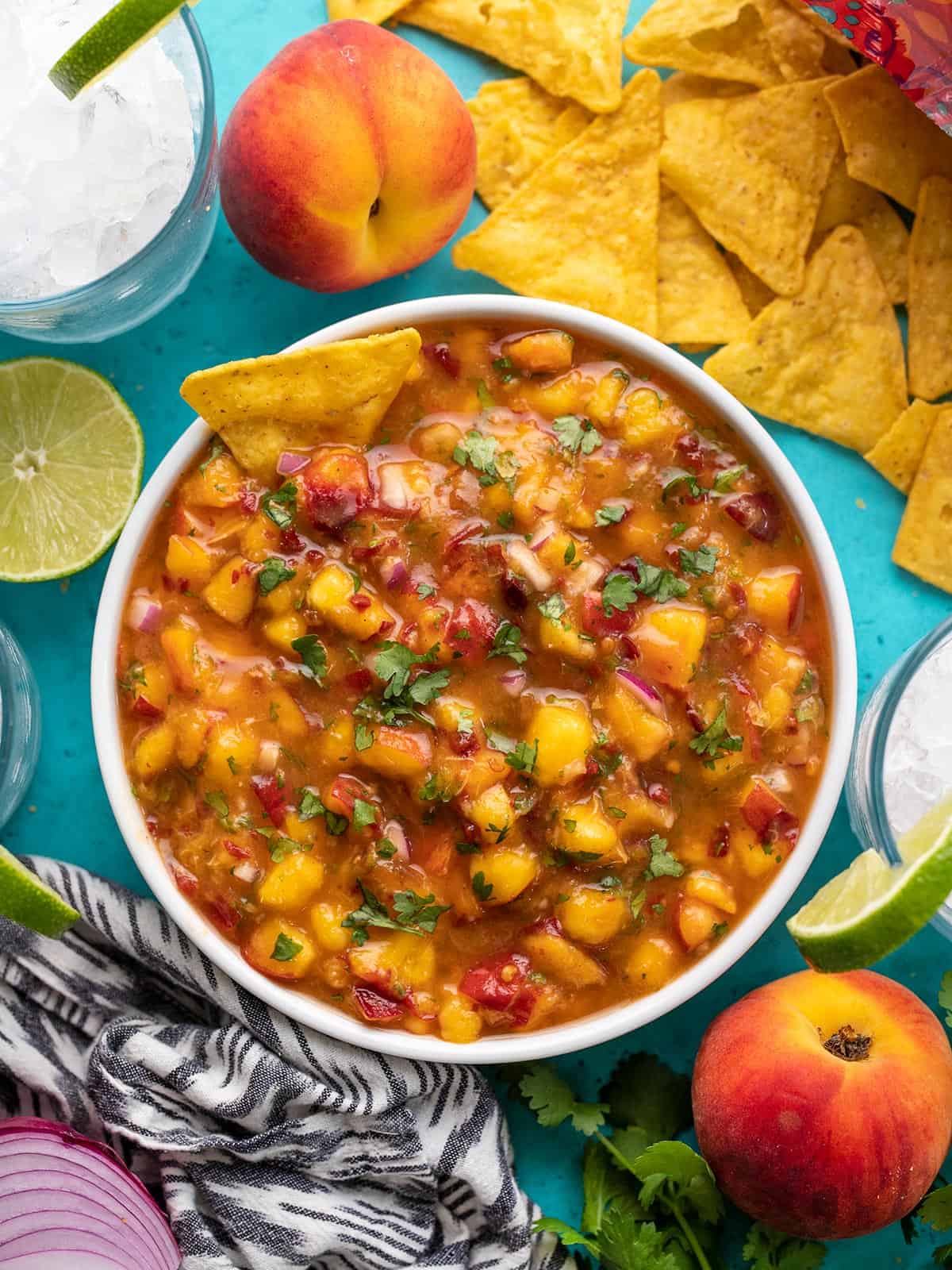 Overhead view of a bowl full of chipotle peach salsa with chips.