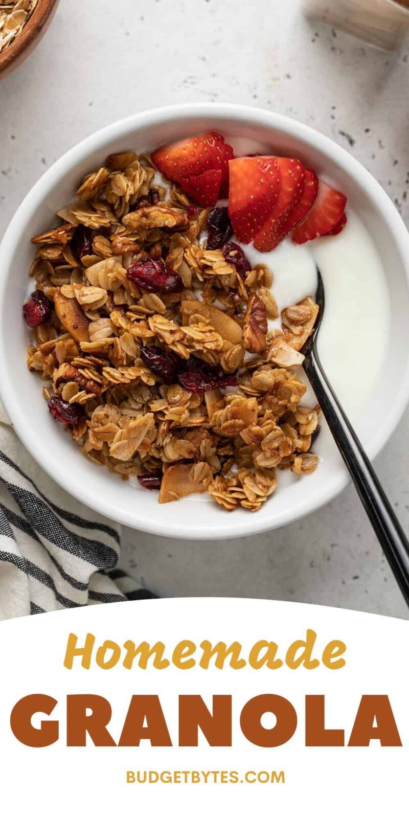Overhead view of a bowl of yogurt topped with granola and strawberries.