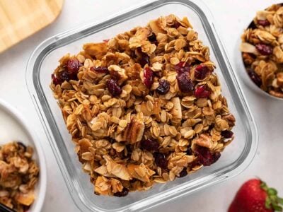 Overhead view of homemade granola in a glass storage container.