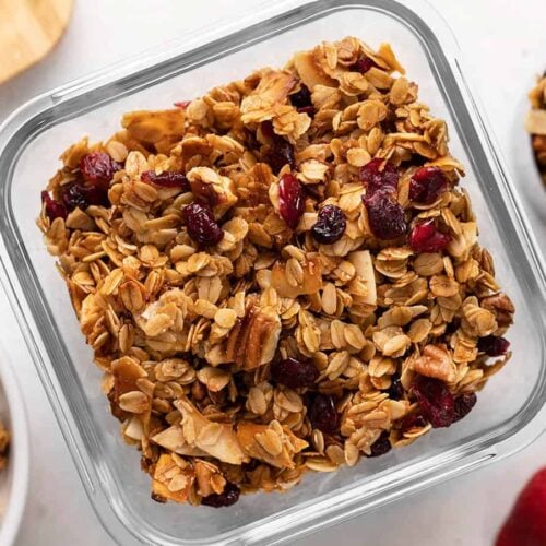 Overhead view of homemade granola in a glass storage container.