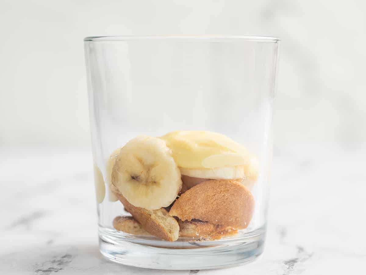 Vista laterale di wafer e banane in un bicchiere.