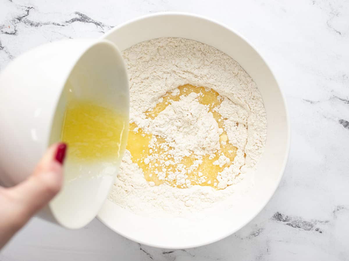 Melted butter being poured into the bowl of dry ingredients.