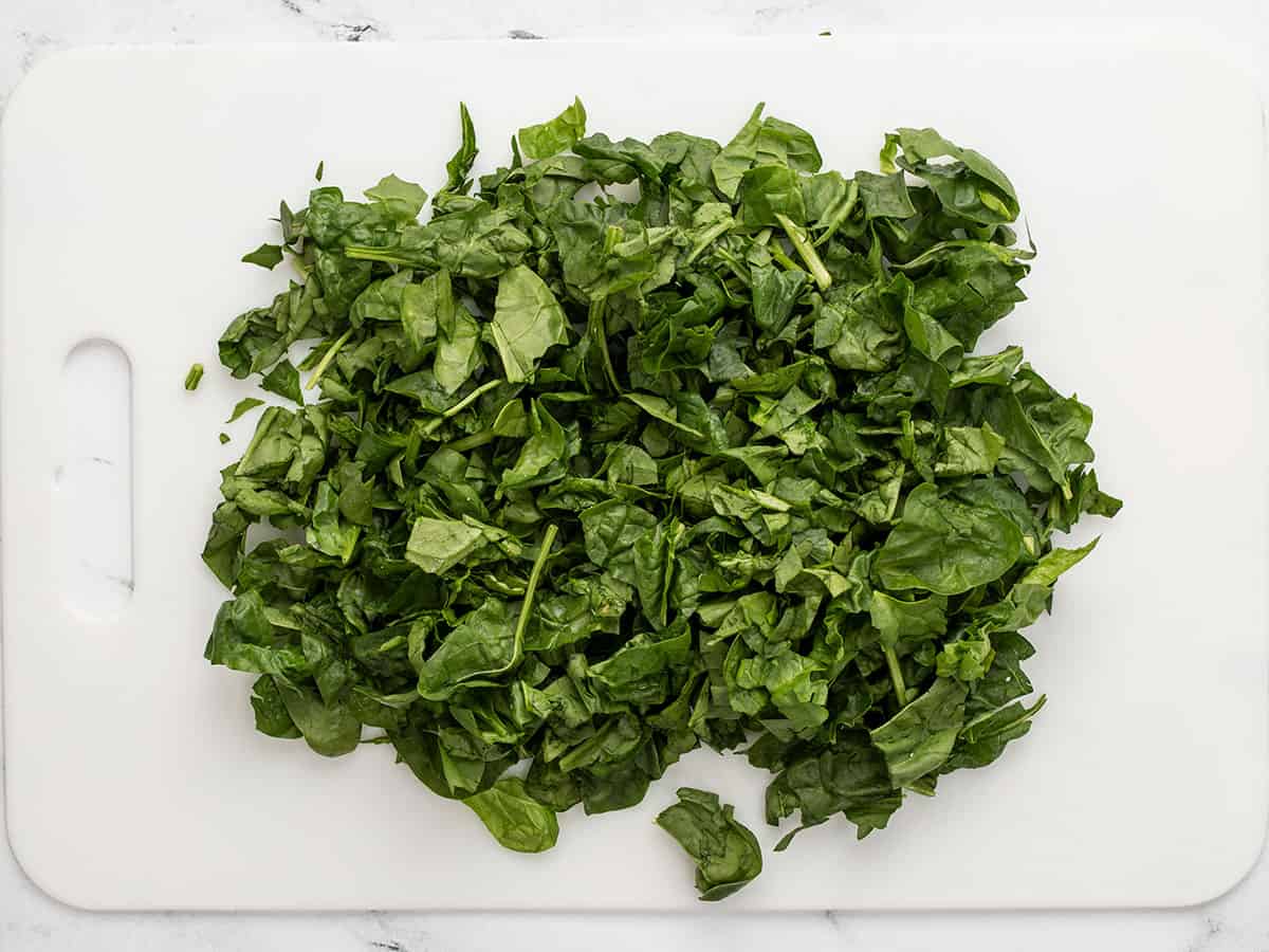 Chopped spinach on a cutting board.