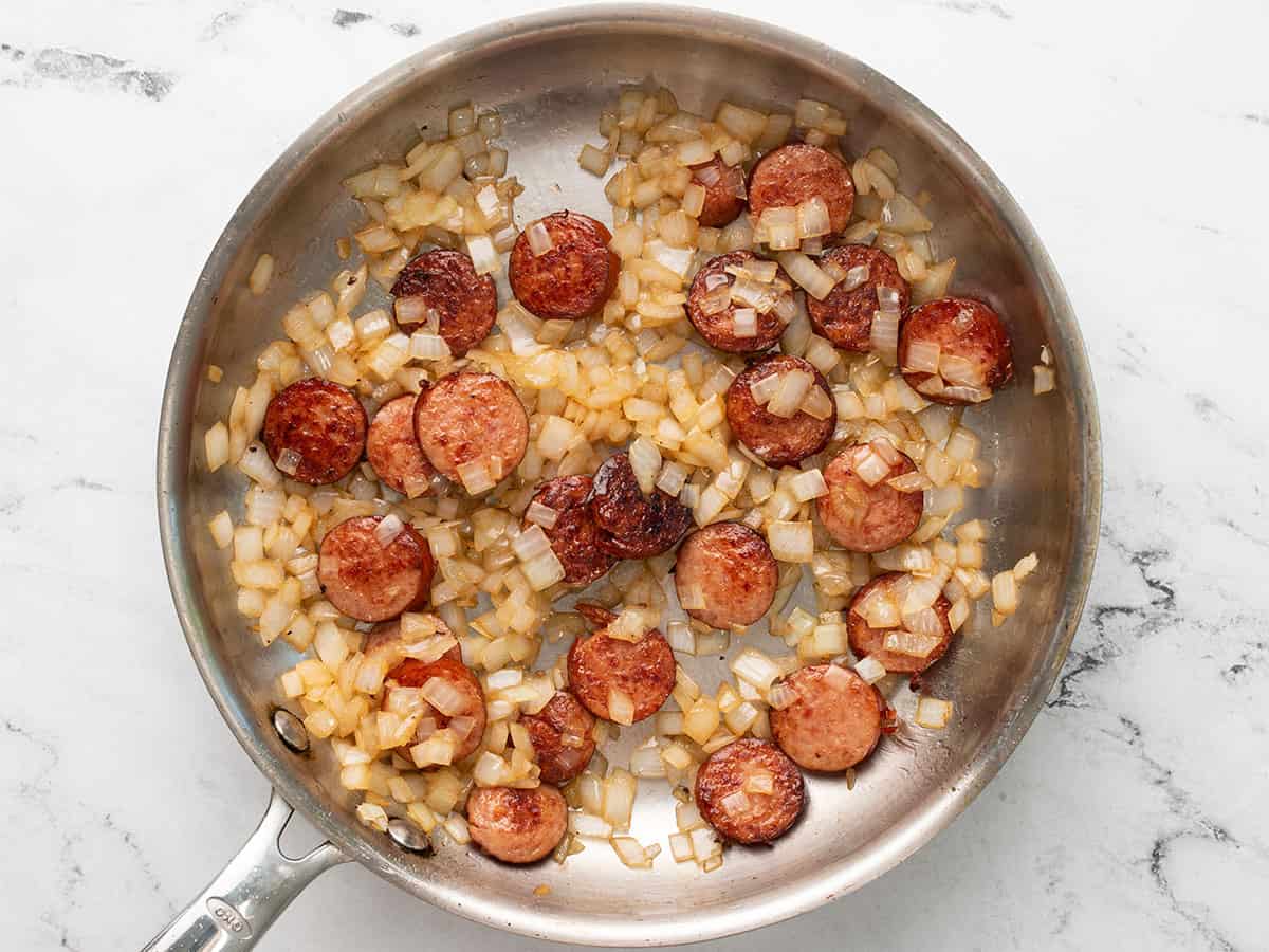 Sautéed onions in the skillet with sausage.