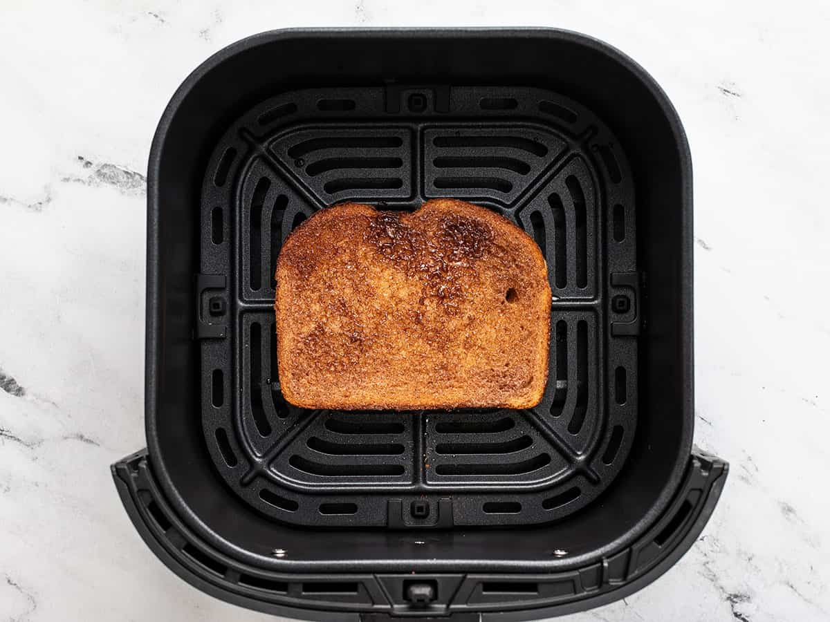 Overhead shot of one side of cooked cinnamon toast in an air fryer basket.