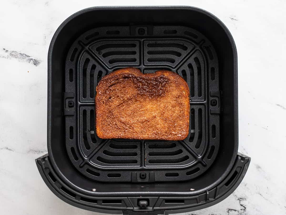 Overhead shot of cooked cinnamon toast in an air fryer basket.