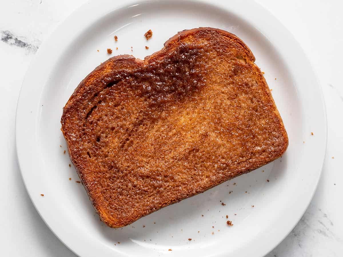 Overhead shot of air fried cinnamon toast on white plate.