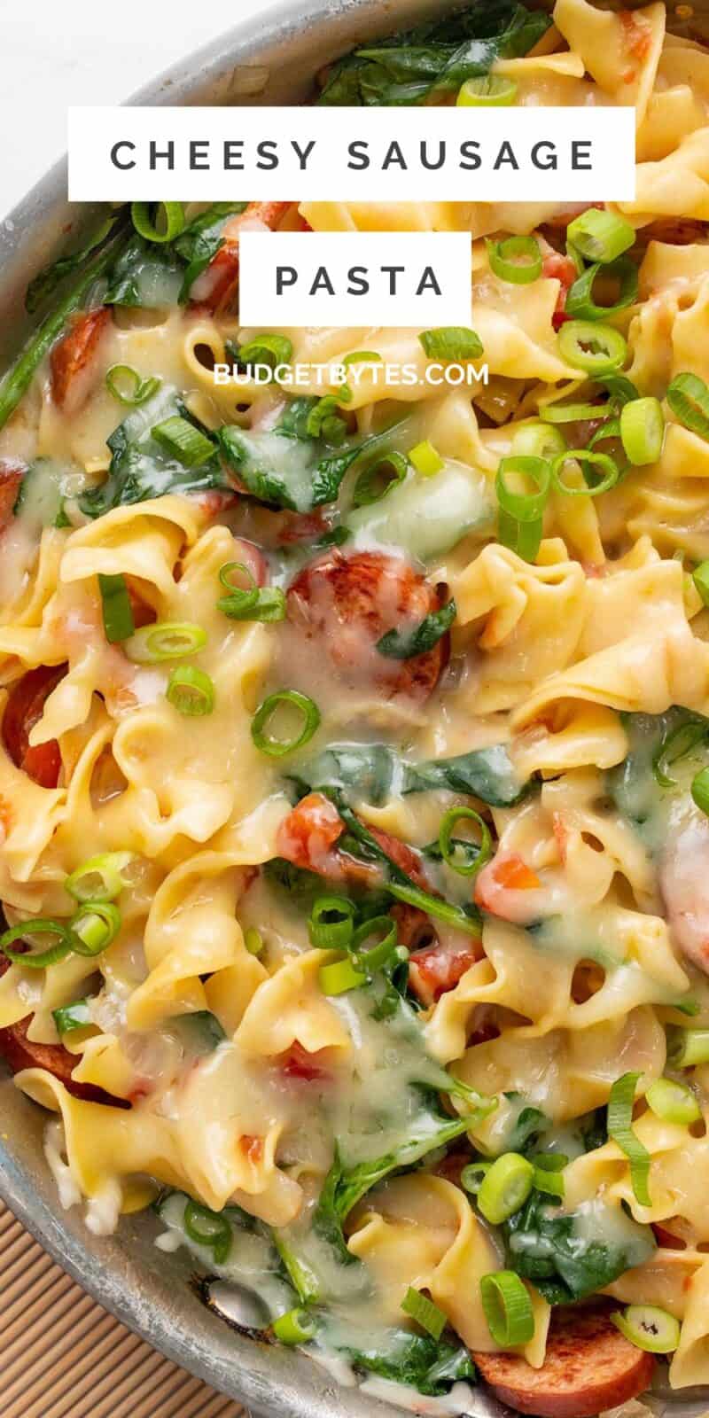 Close up overhead view of cheesy sausage pasta in the skillet, title text at the top.