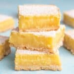A stack of three lemon bars on a blue background.