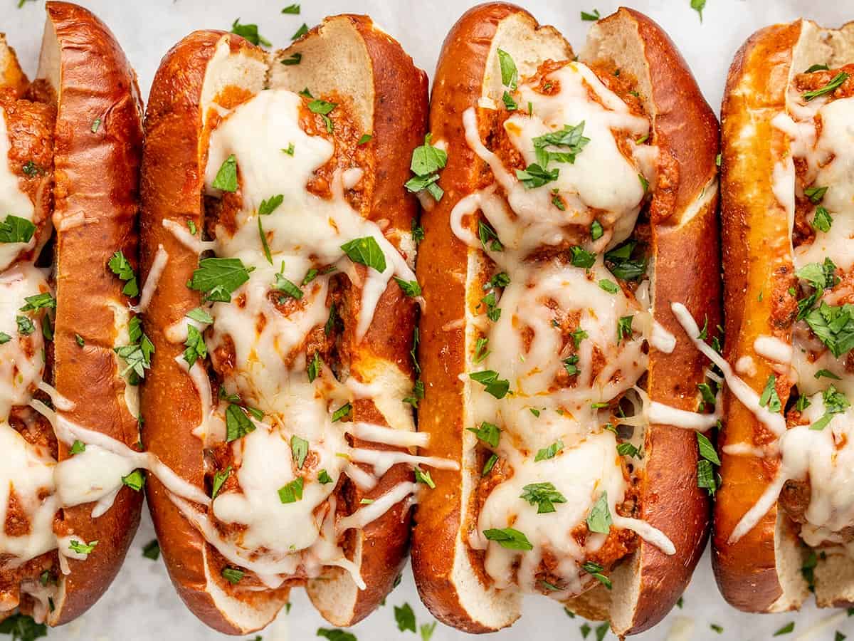 Overhead view of baked meatball subs garnished with parsley.