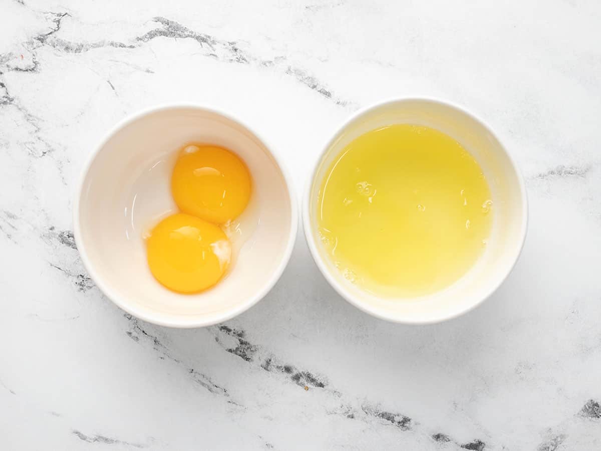 Overhead shot of egg yolksd and egg whites in separate ramekins.