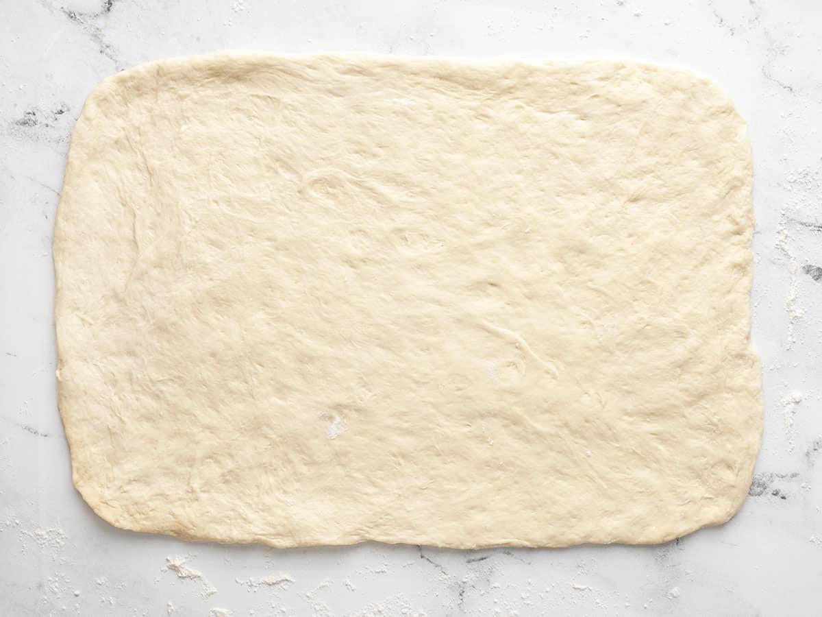 Pizza dough rolled out into a rectangle.