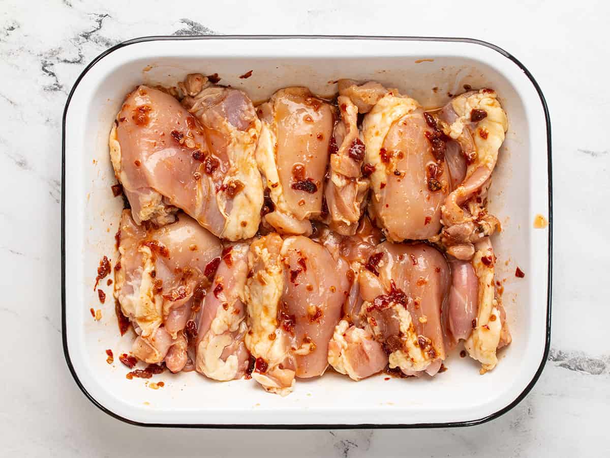 Marinating chicken thighs in a shallow dish. 