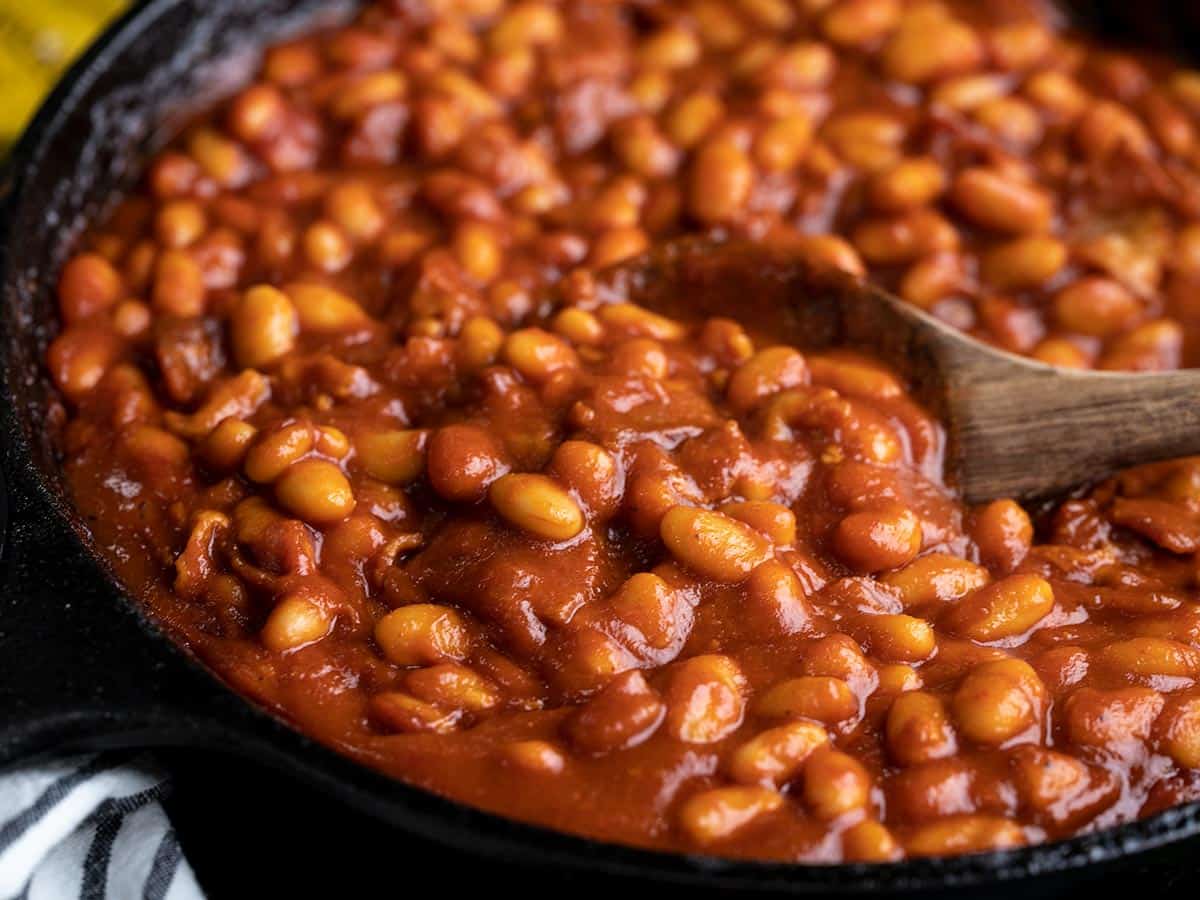 Close up side view of baked beans in the skillet.