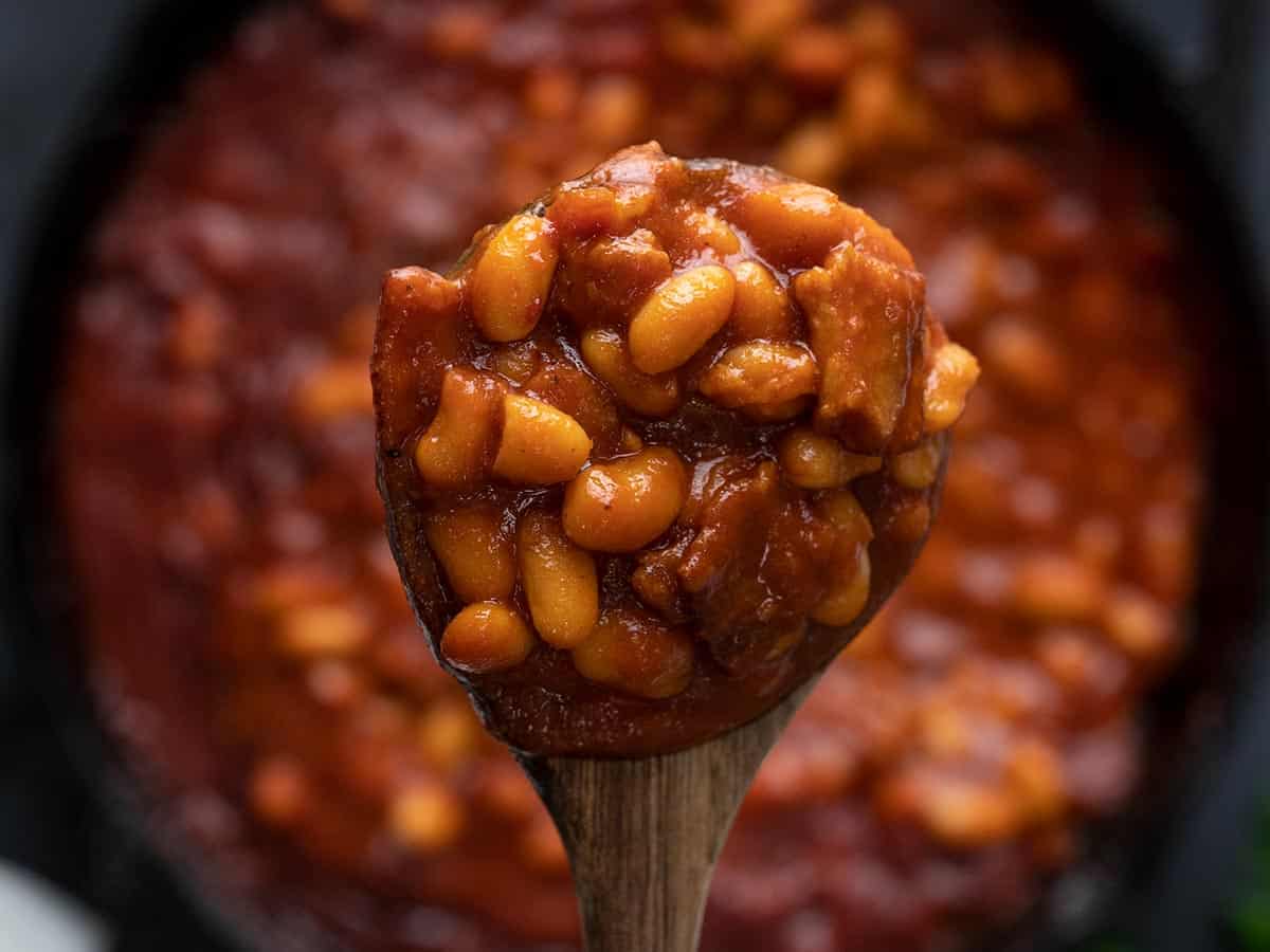 Baked beans on a spoon held close to the camera.