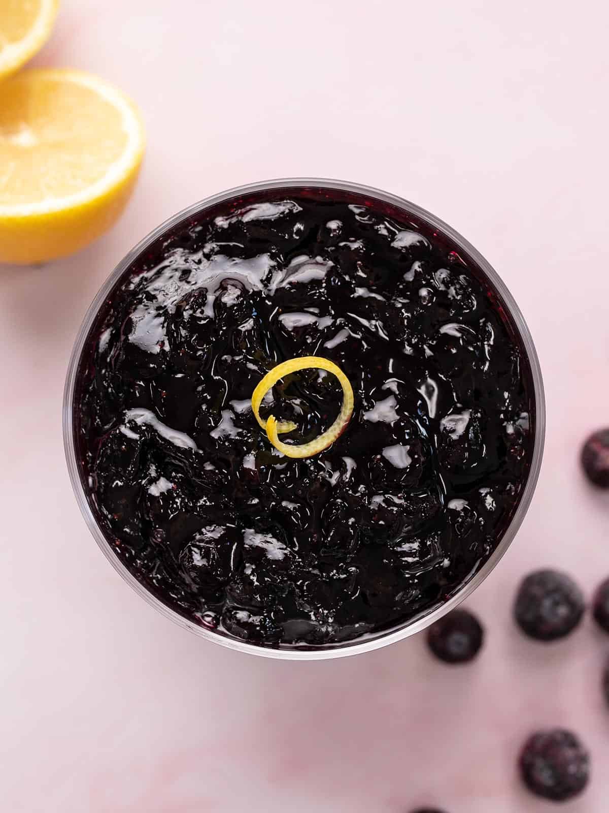 Overhead shot of blueberry sauce in a serving bowl with lemon zest.
