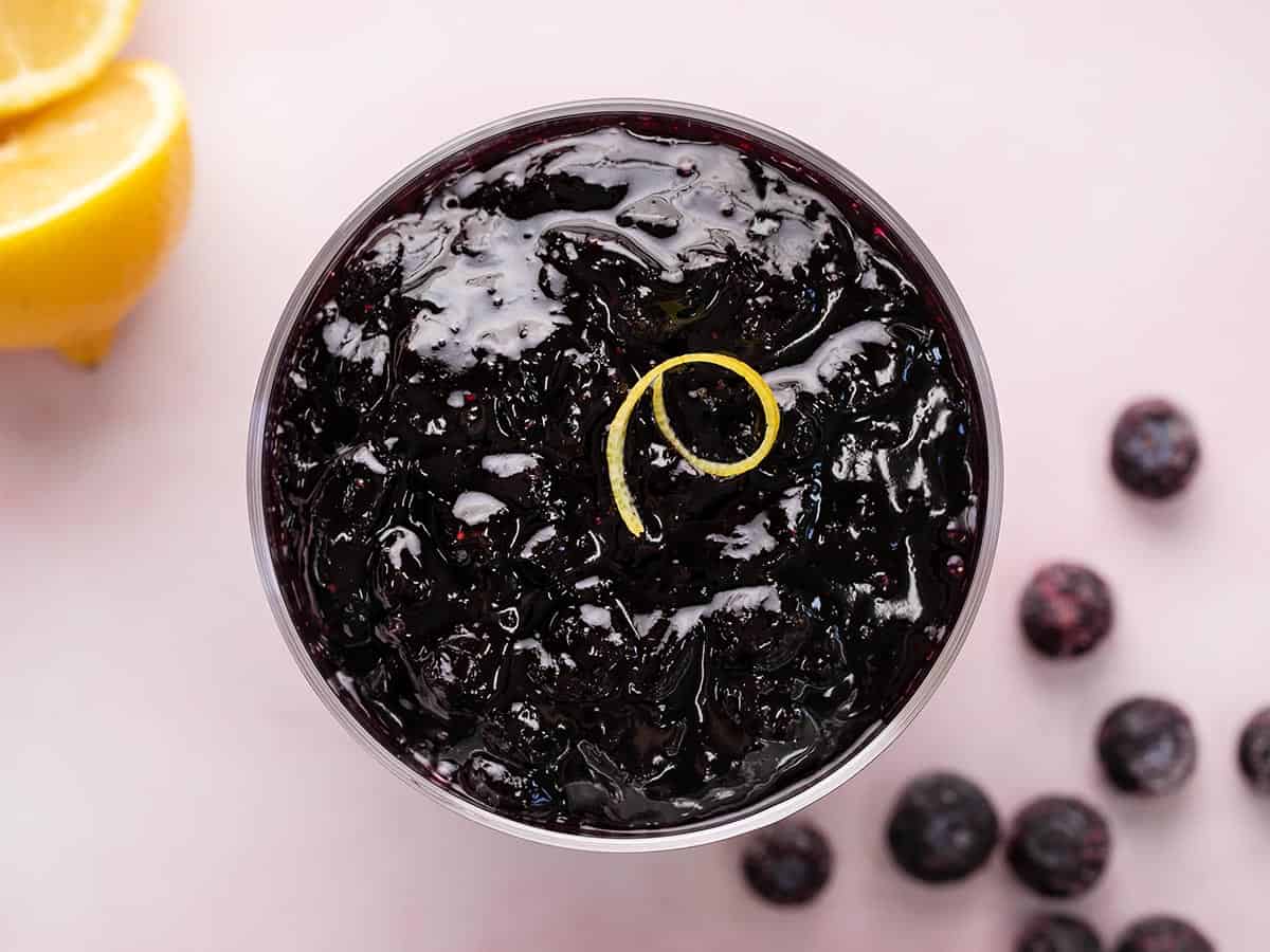 Overhead shot of blueberry sauce in a serving bowl with lemon zest.