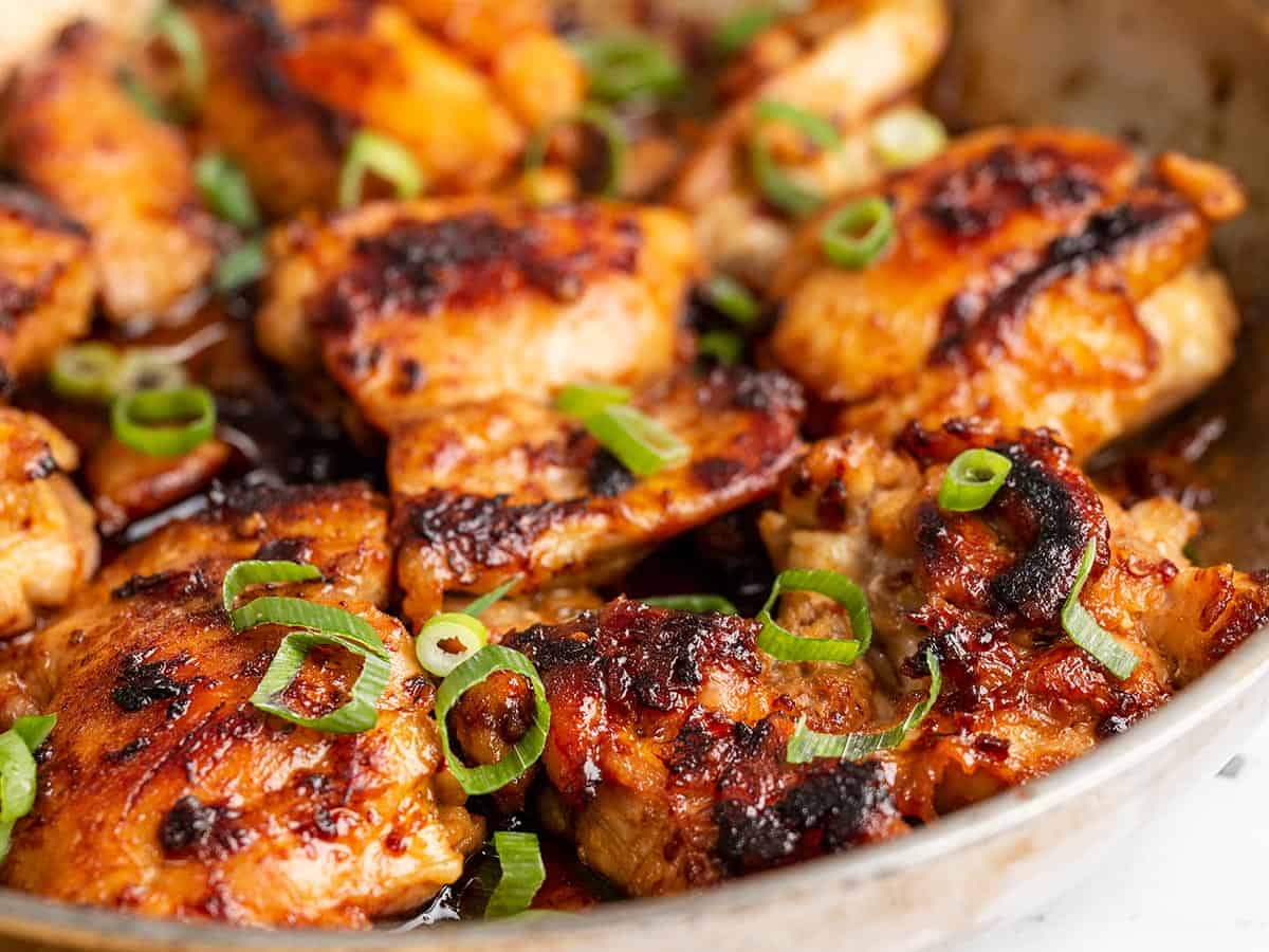 Close up side view of honey chipotle chicken in a skillet.